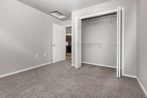 A room with a carpeted floor and a white door.