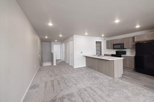 A spacious living room with a television and a kitchen area.