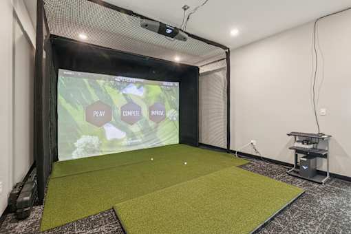 A projection screen in a room with a green carpet.