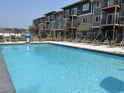 Sparkling blue pool surrounded by lounge chairs.