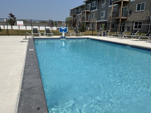 Sparkling blue pool surrounded by lounge chairs.