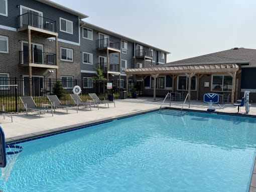 Sparkling blue pool surrounded by lounge chairs.