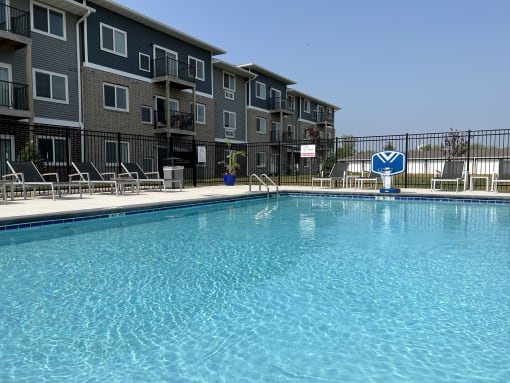 Sparkling blue pool surrounded by lounge chairs.
