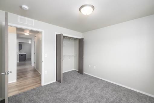 A room with a grey carpet and white walls.