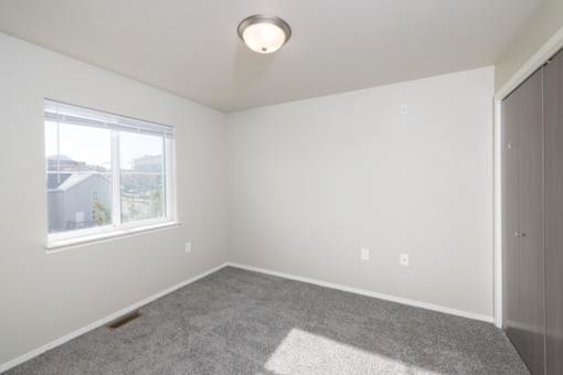 A room with a window and a carpet on the floor.