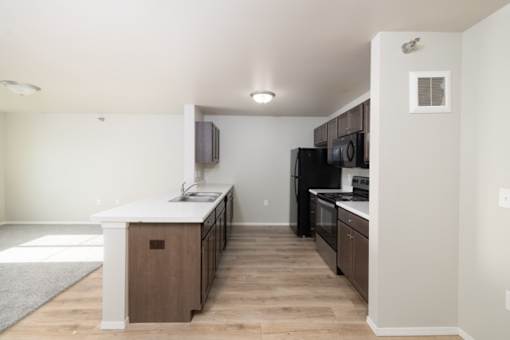 A kitchen with a white counter top and wooden cabinets.