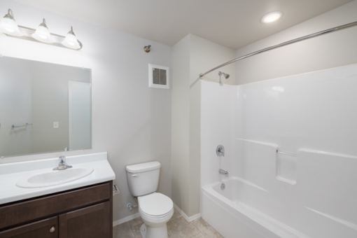 A white bathroom with a toilet, sink, and bathtub.