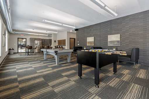 A billiard table is in the middle of a room with a carpeted floor.