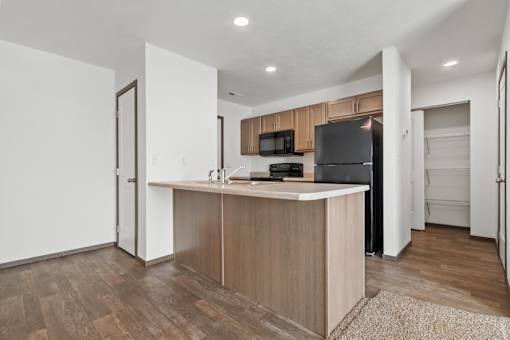 A kitchen with wooden floors and a white ceiling.