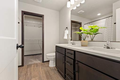 A bathroom with a toilet, sink, and mirror.
