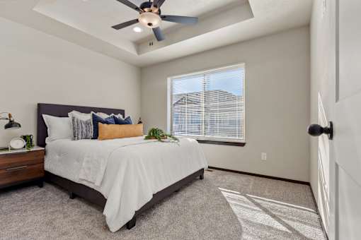A bedroom with a bed, nightstand, and window.