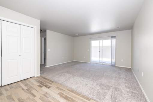 A room with a white door and a carpeted floor.