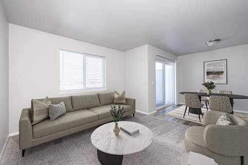 A living room with a grey couch, a white coffee table, and a grey chair.