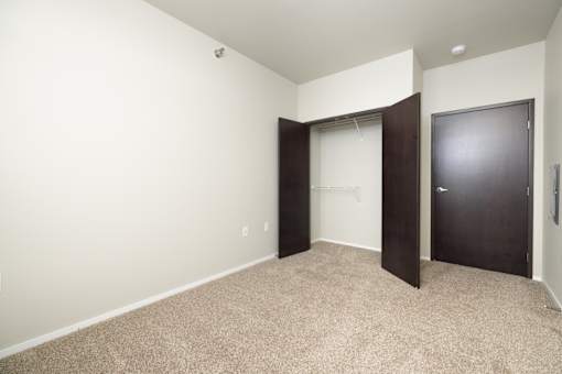 A room with a carpeted floor and a black door.