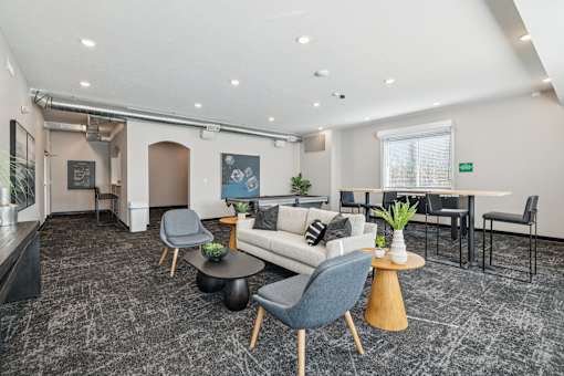 A modern living room with a grey carpet and furniture.