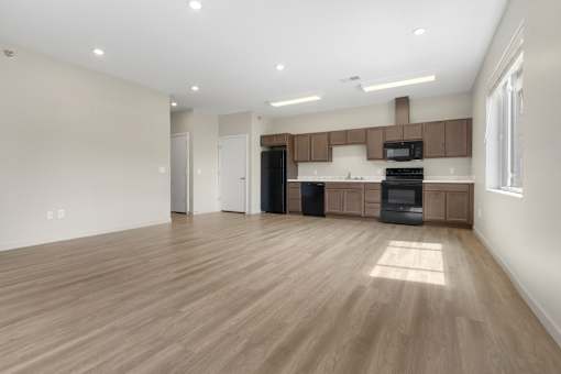A spacious kitchen with wooden floors and modern appliances.