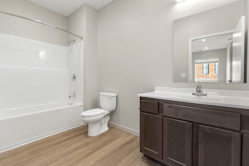 A white toilet sits in a bathroom next to a sink.