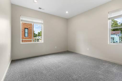 A room with a window showing a brick building outside.