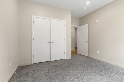 A room with two white doors and a carpeted floor.