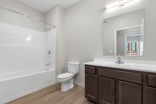 A white bathroom with a toilet, sink, and bathtub.
