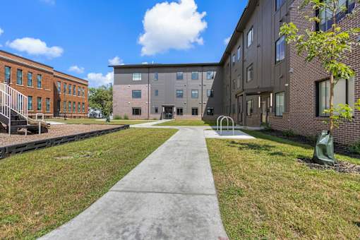 A concrete walkway leads between two buildings.