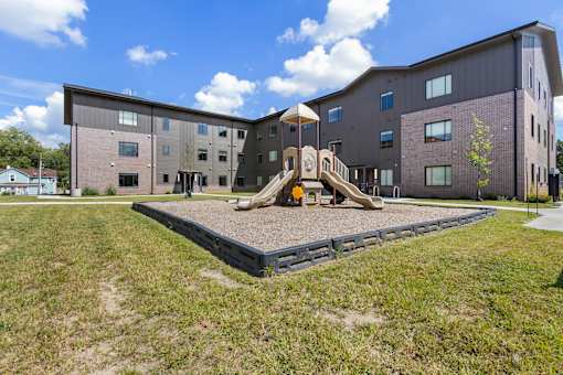 A playground area in front of a modern building.