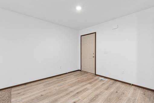 A room with a wooden floor and a door.