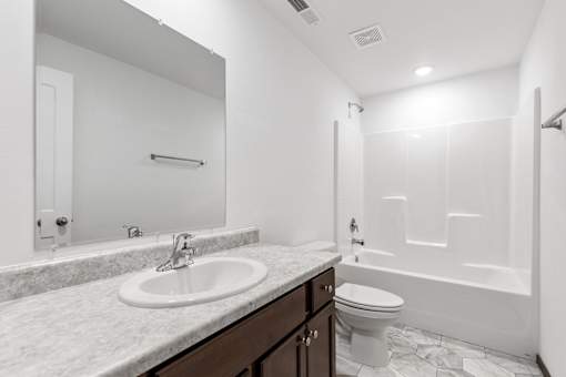 A white bathroom with a sink, toilet, and bathtub.