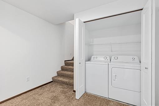 A white laundry room with a washer and dryer.