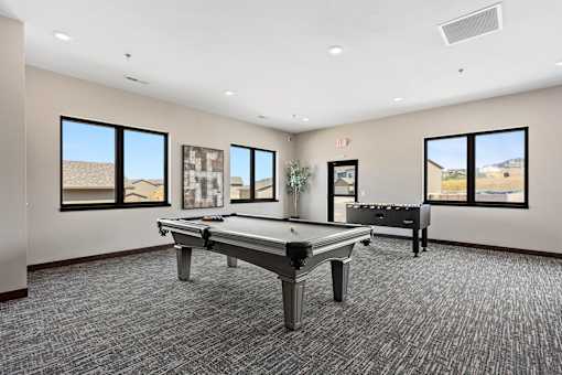 A room with a pool table and a bench.