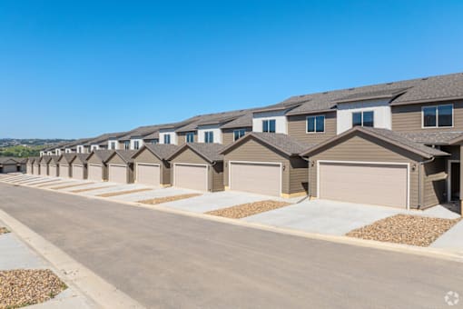 A row of houses with garages in front.