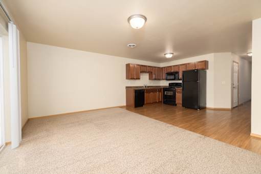 A kitchen area with a black fridge, microwave, and oven.