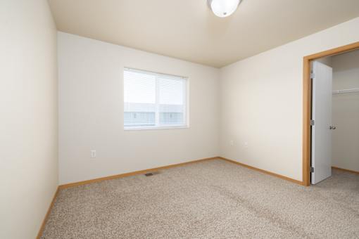 A room with a carpeted floor and a window.