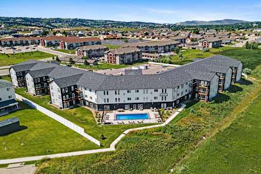 A large building with a pool in the middle of a grassy area.