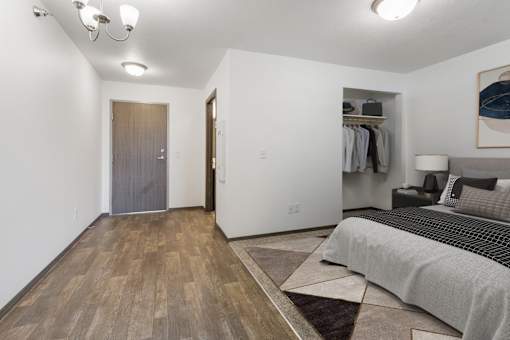 A bedroom with a bed, a wardrobe, and a painting on the wall.