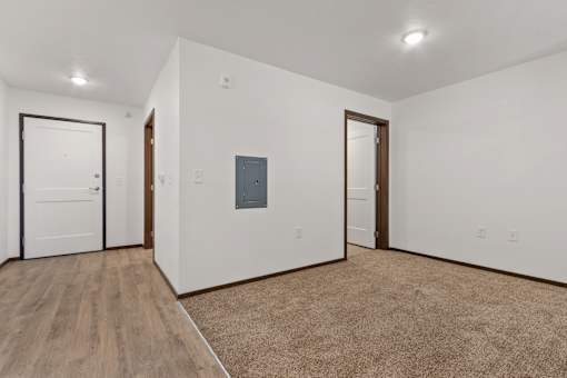 A room with a white wall and a brown carpet.