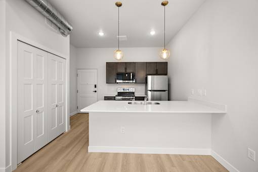 A kitchen with white cabinets and a white island with a sink.