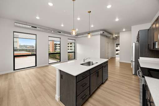 A modern kitchen with a large island and wooden floors.