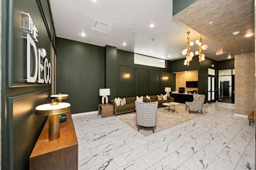 A reception area with a black sofa and a gold table.