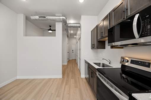 A kitchen with a black stove top oven and a black microwave above it.