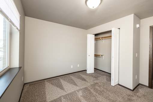 an empty room with a closet and a window