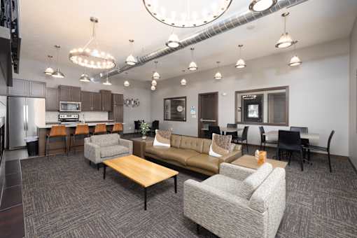 A modern office space with a kitchen area and seating arrangements.