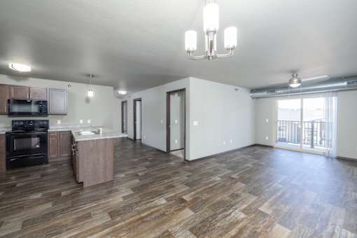 A living room with a kitchen area in the background.