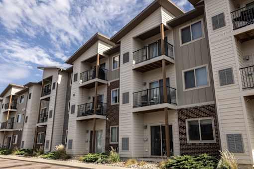 A row of modern apartment buildings with balconies and windows.