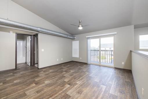 A room with wooden flooring and a ceiling fan.