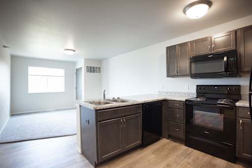 A kitchen with dark brown cabinets and appliances.