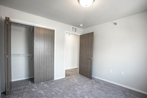 A room with two doors and a carpeted floor.