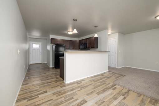 A kitchen with a white counter and wooden flooring.