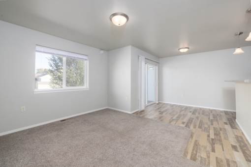 A room with a carpeted floor and a window.