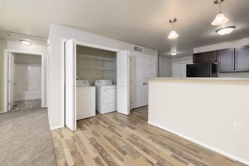 A kitchen area with a white counter and a black fridge.